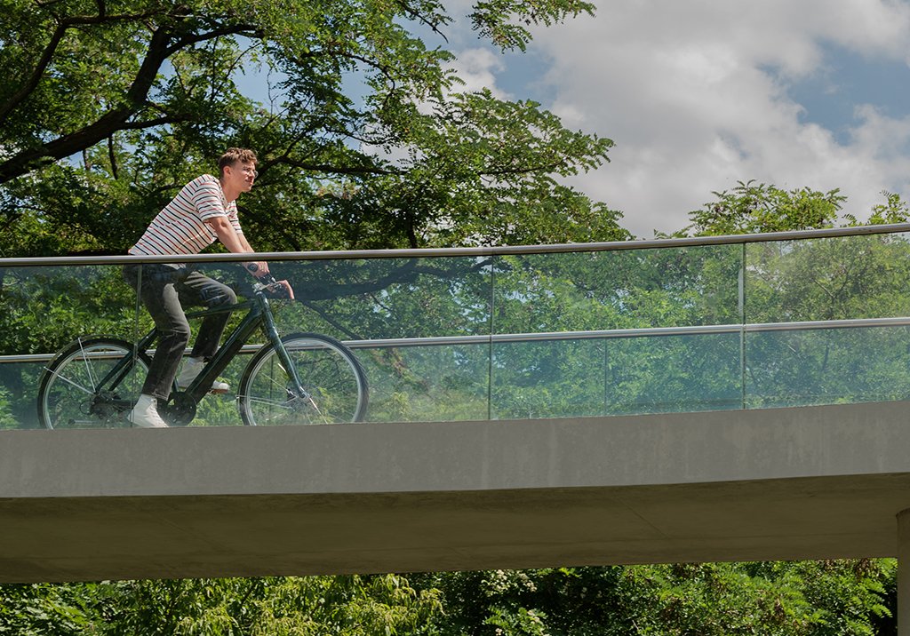 Mand på cykel over en bro